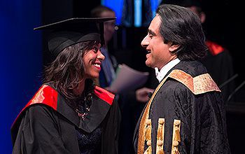 A student greets the Chancellor as she crosses the stage