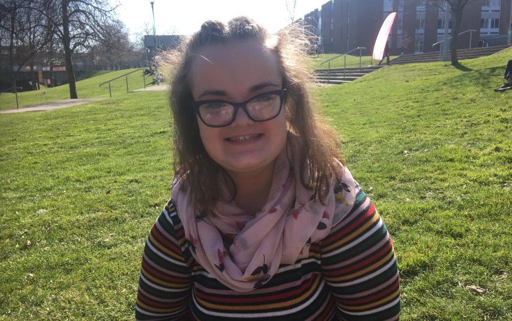 Portrait photo of Emma Beeden outside on campus on a sunny day