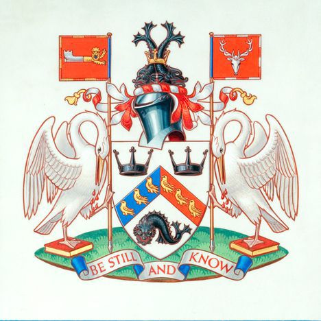 The University of Sussex coat or arms on vellum, featuring six martlets, two crowns, two pelicans, a dolphin and the motto 'be still and know.'