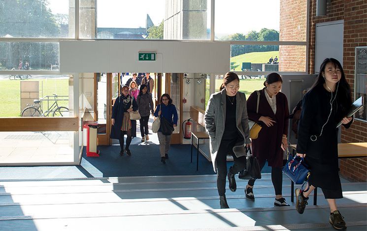 Several people walk up the large blue steps in the Arts A lecture theatre building.
