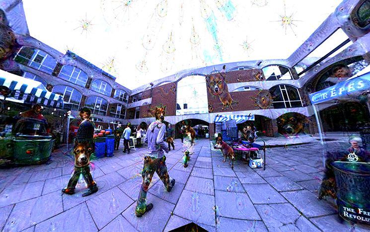 Example of view inside the 'hallucination machine', where a panoramic view of Falmer House quad has rainbow colours and the faces of dogs emerging from walls.