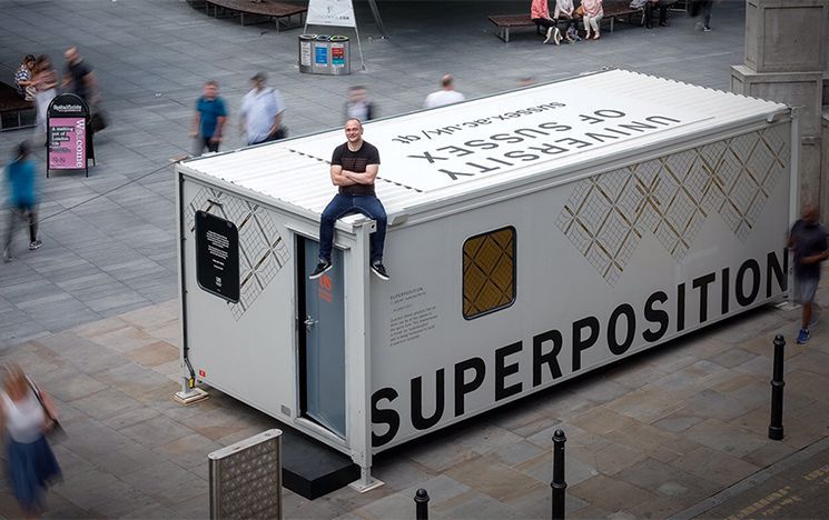 Prof Winfried Hensinger sits on top of a pop-up quantum computing lab, built inside of a shipping container.