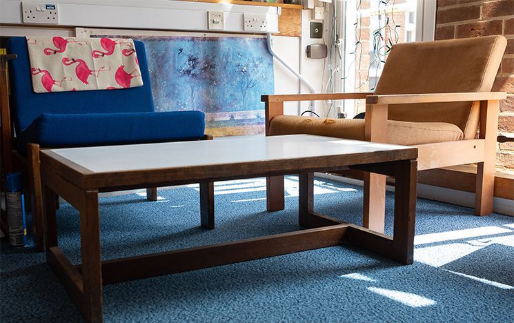 Two low chairs with fabric-covered cushions and a coffee table, designed by University architect Sir Basil Spence, currently being used in Arts A.