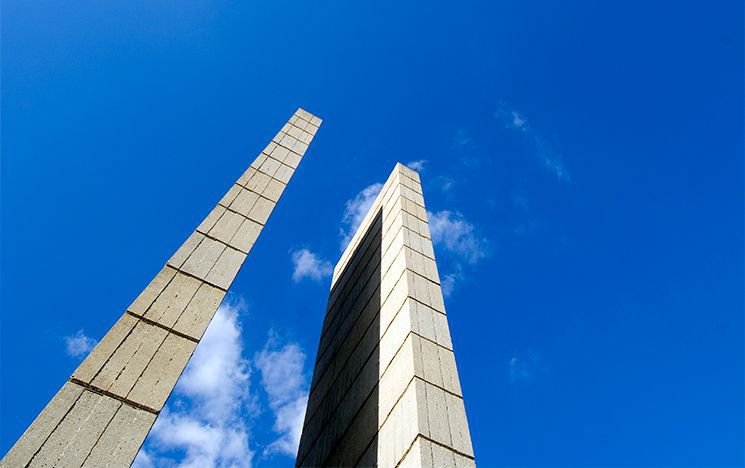 The two concrete Arts A towers stand out against a clear, vivid blue sky.