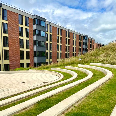 The steps and grass-covered seating of the amphitheatre, with the newer East Slope buildings in the background.