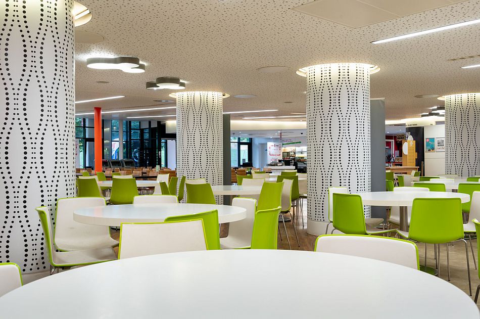 The interior of Eat Central showing the seating area with round white tables and green chairs.