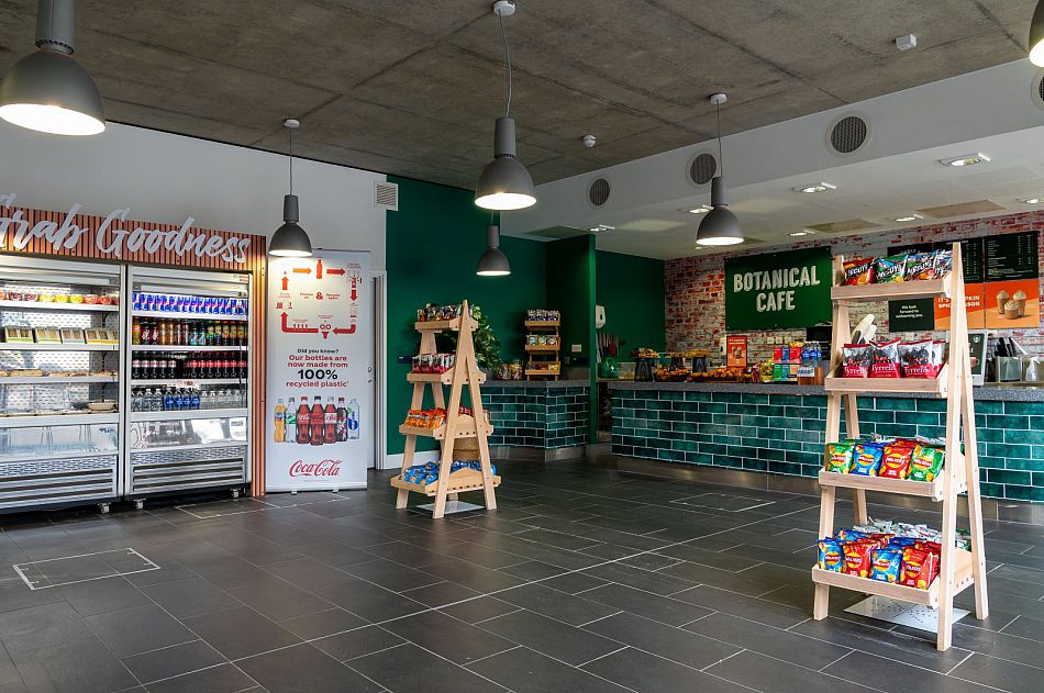 The interior of the Botanical cafe showing the counter and shelves with some food such as crisps