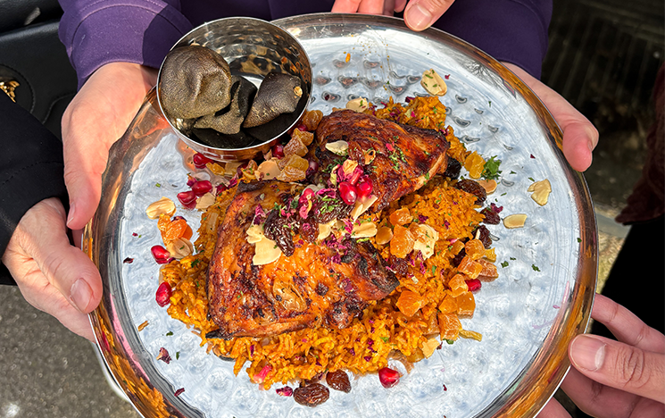 Hands holding a plate of mexican bean wrap.