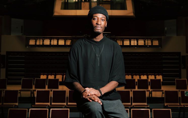 A man dressed in all black looking into the camera