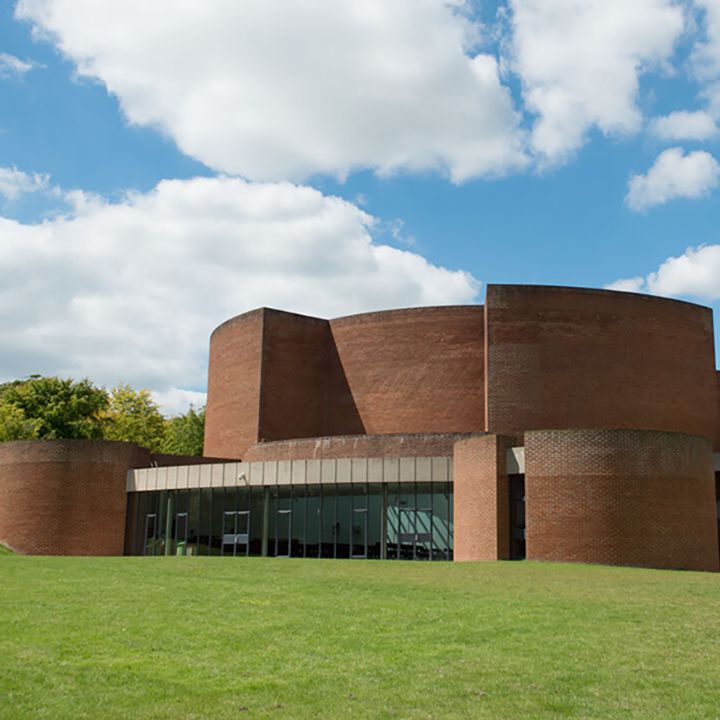 Rounded brick building with grass and sky