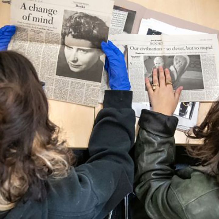 People looking at newspapers from the archives
