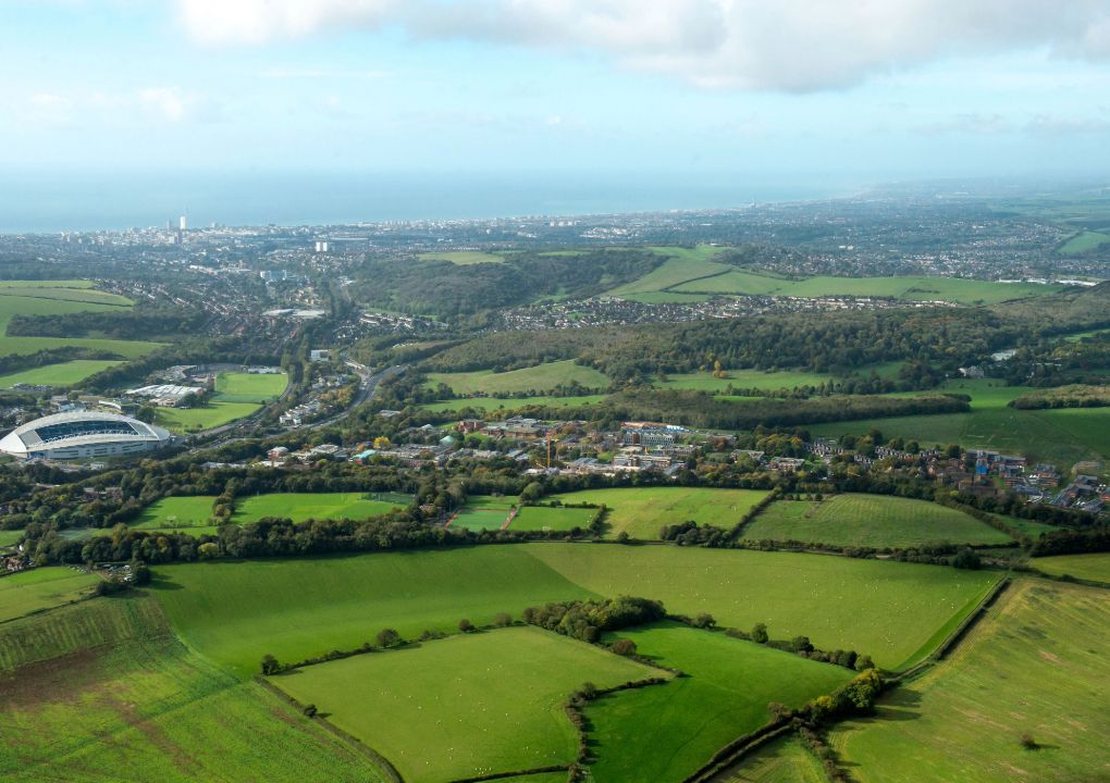 An aerial shot of the Sussex campus, Amex stadium and South Downs and sea