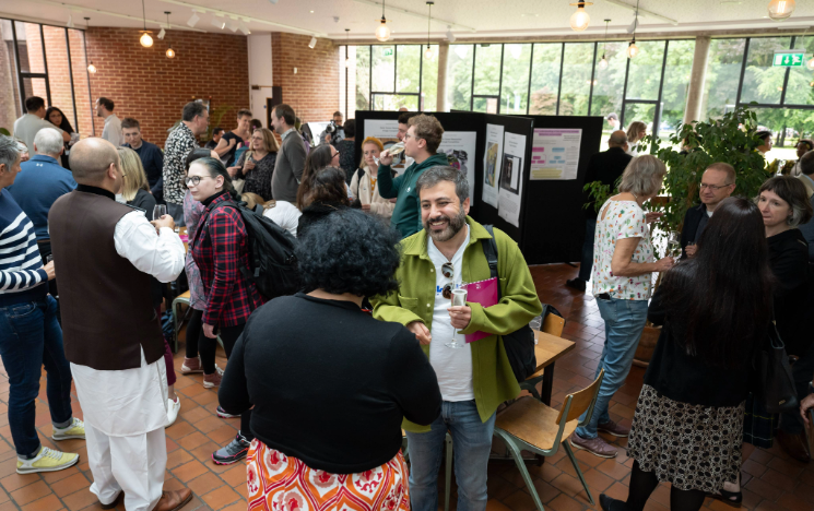 Staff and students socialising at research poster event