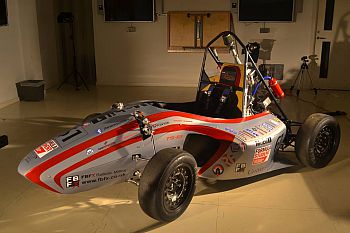 Photo of the formula student car in a brightly lit studio.