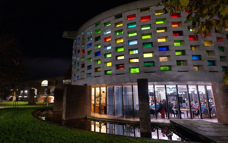 Circular building with coloured glass windows at night