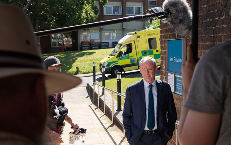 Filming with actor standing in front of ambulance