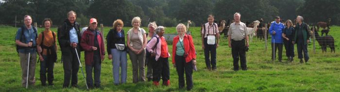 This is a group photograph of the London Blind Ramblers Club with the lamas on a cloudy day in East Sussex, taken 2009.