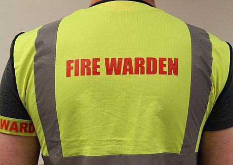 A photo of a man wearing a "Fire Warden" hi-viz vest