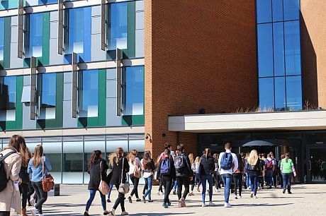 A photo showing a stream of students entering a public building