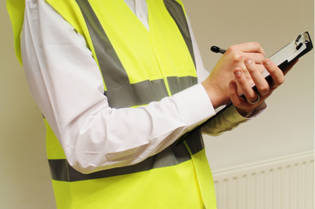 A photo of a person wearing a hi-viz vest with a clipboard