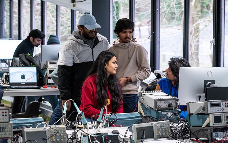 Students working with various equipment in electronics lab