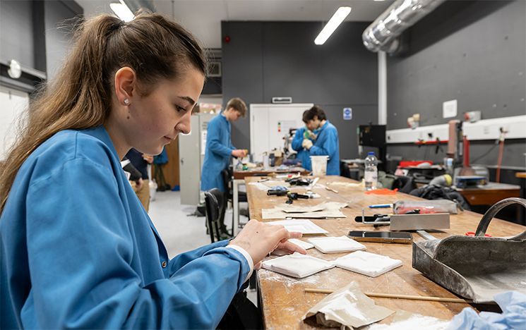 A student at a workbench working with materials