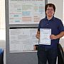 Andrew Robertson holds out his certificate and poses for a photograph by his prize-winning poster (top).