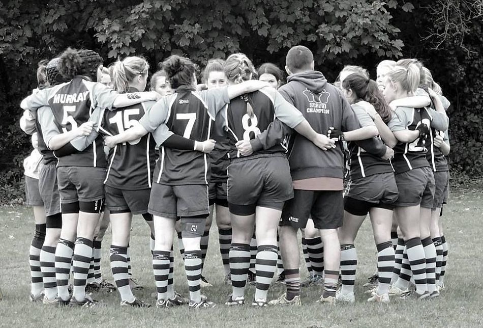 Women's rugby team in a huddle