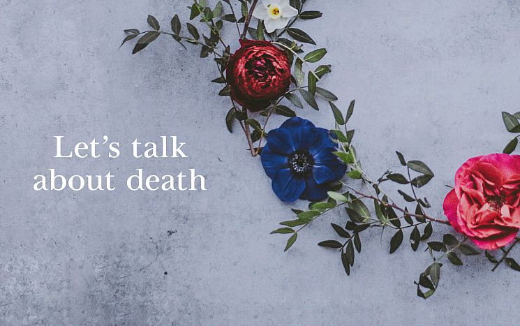 Wreath of flowers against a mottled grey background, with the words Let's talk about death