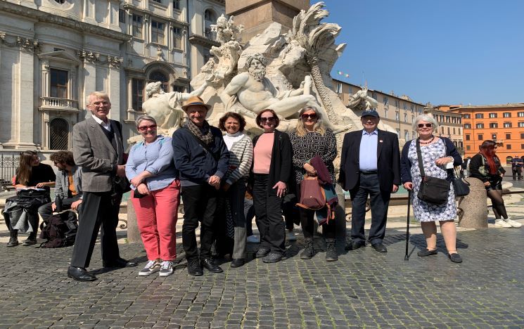 Guests on the Rome trip standing in front of a fountain