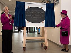 Her Majesty unveils a plaque marking the opening of The Keep, with a member of staff from the archive