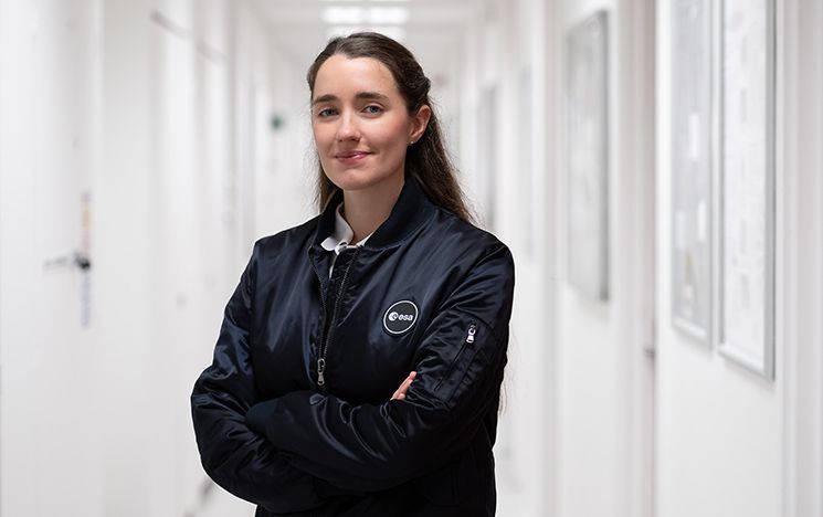 Dr Rosemary Coogan stands in white corridor wearing ESA logo jacket