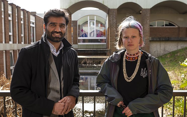 Naimat Zafary and Violetta Korbina stand in front of Arts pond on the Sussex campus