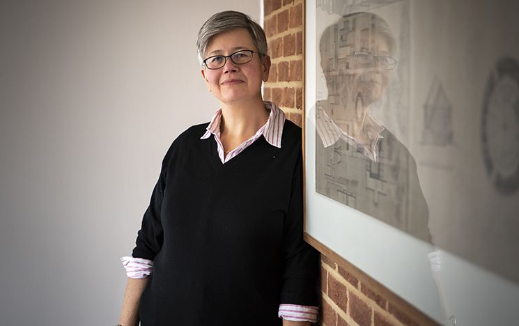 Vice-Chancellor Sasha Roseneil stands next to picture reflecting her image