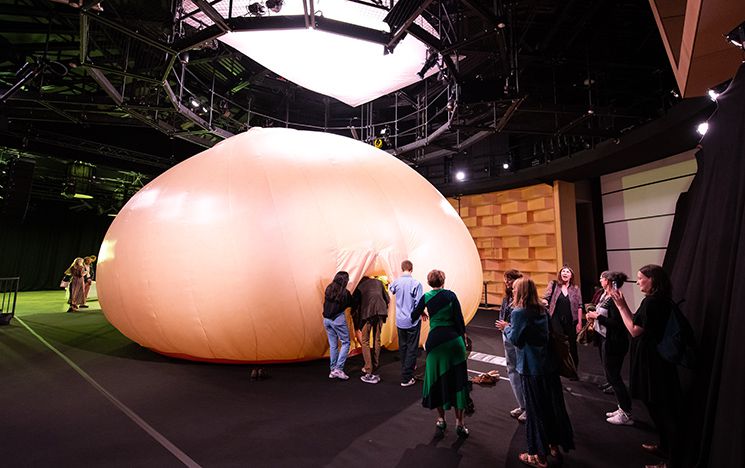 Visitors queue to enter the Big Breast installation inside the Attenborough Centre for Creative Arts