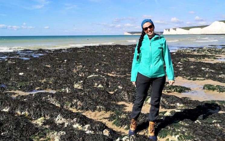 Brittany stood smiling on a beach near the Seven Sisters cliffs.