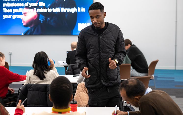 Darren Tenkorang in Sussex seminar room with students at tables