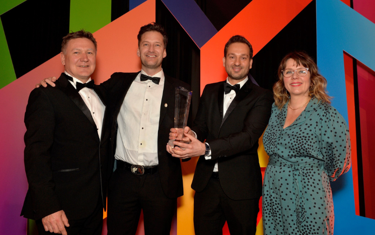(From left to right): Marcus Atkinson, External Engagement Manager for the Business School, Prsnt creators David Parr and Omid Moallemi, who is holding the award they received, with comedian and actor Kerry Godliman at the Gatwick Diamond Awards.