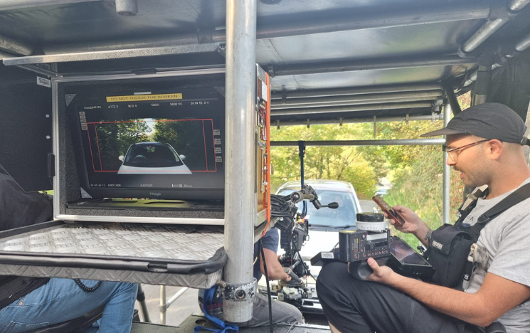 On the back of the low loader with Max Day during filming One Night Only. The people on the low loader are looking into the camera at the scene in front of them.