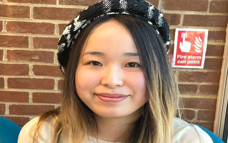 Cooper-Carlson PhD scholar Yidan Xu wearing a black and white beret and smiling
