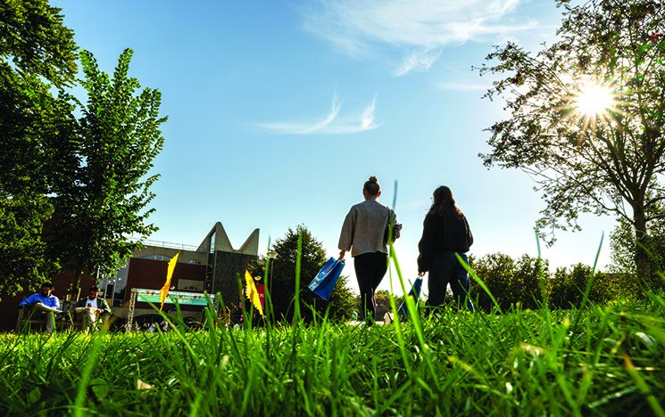 Rear view of two students walking on campus