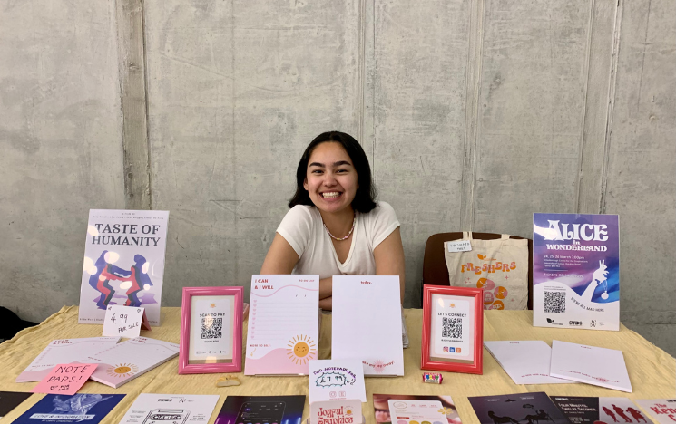 Rachel Nielsen sat at a stall selling items she designed such as notepads and a tote bag.
