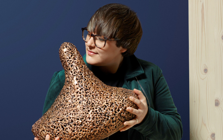 Tasha Marks holding a bronze sculpture titled ‘5318008’ that emits the smell of human breastmilk.