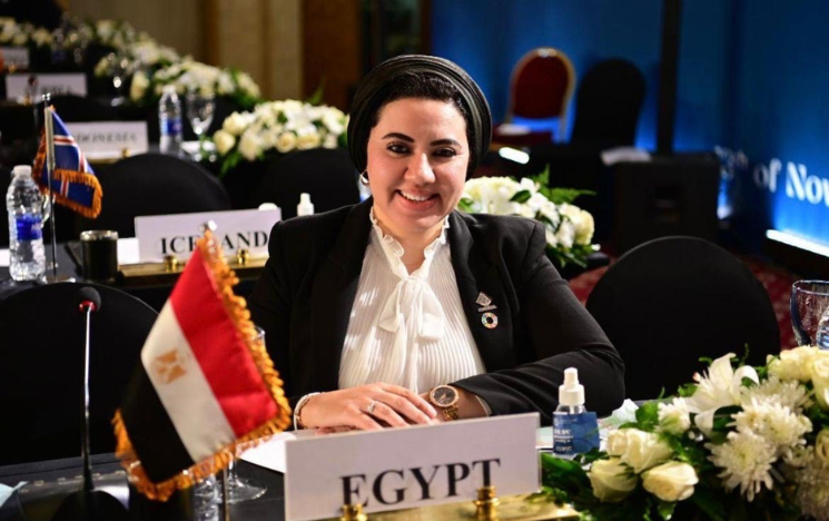Amira Saber sat at a table with a sign that reads Egypt and an Egyptian flag.