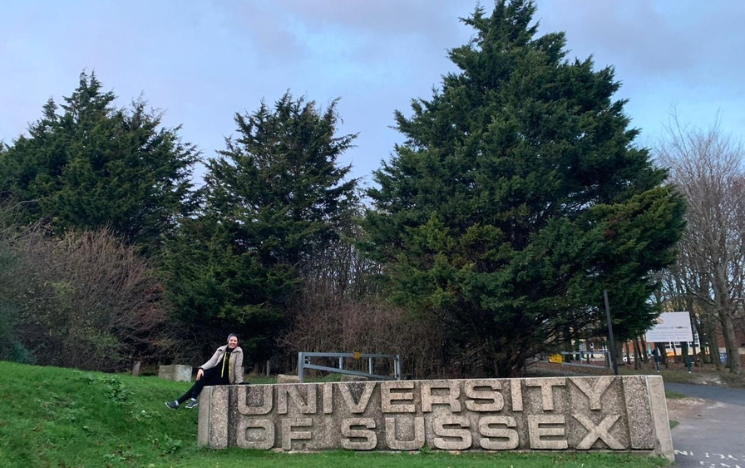Amira Saber set on the University of Sussex concrete sign.