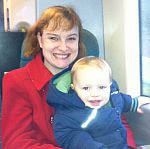 Jessica sits with her son on a train