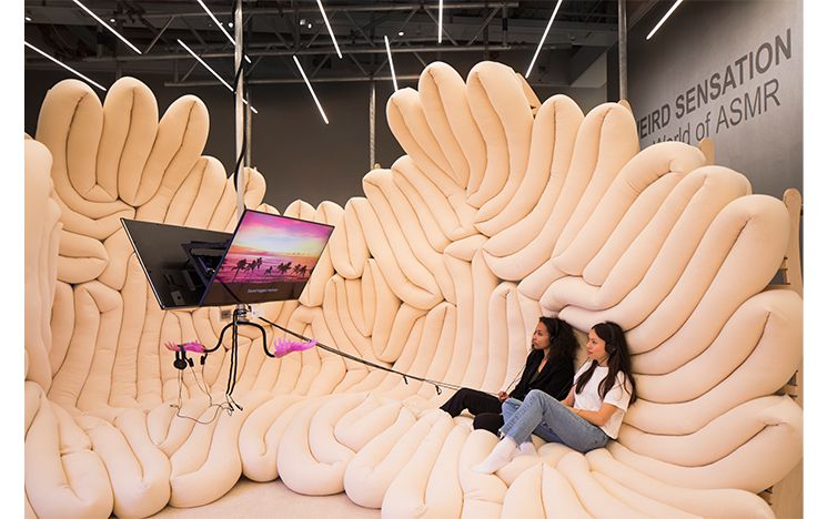 Two woman laying on cushion cloud watching screen