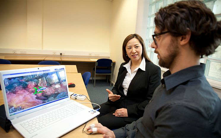 Woman showing info on laptop to man