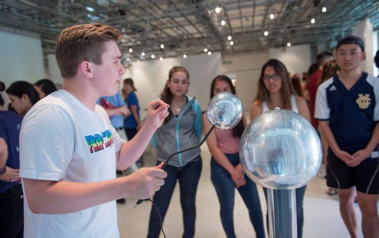 Student demonstrating electrostatics to school children at an public engagement event