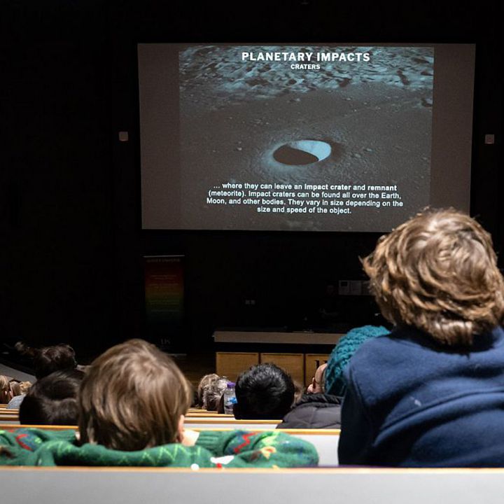 Students looking at astronomy slide in auditorium